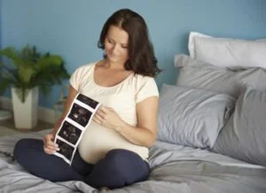Pregnant woman browsing ultrasound image of her baby